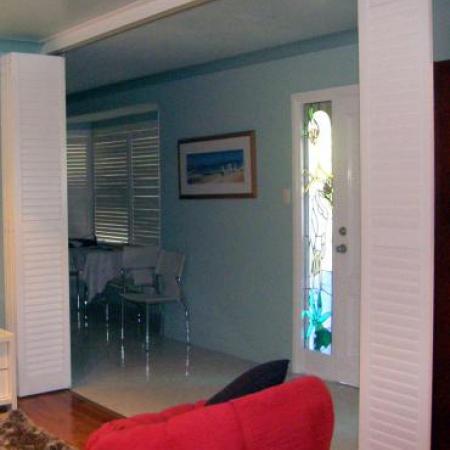 Stylish in white: Plantation Shutters look good in any location. Leah's Painted Shutters brightens the room dramatically and contrasts well against the dark furniture. This room has sliding shutters; creating the perfect media room when needed. 